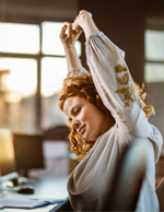 Person stretching at desk while working