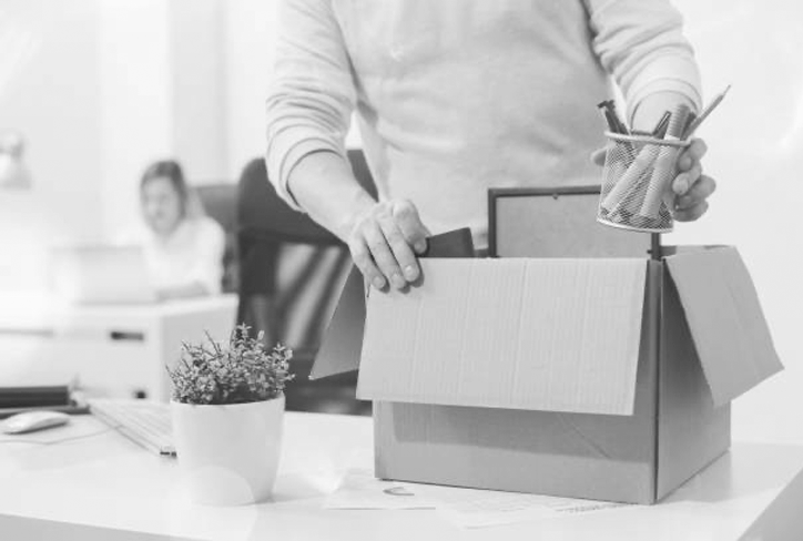 Photo of person packing up belonging at work after being let go (fired)