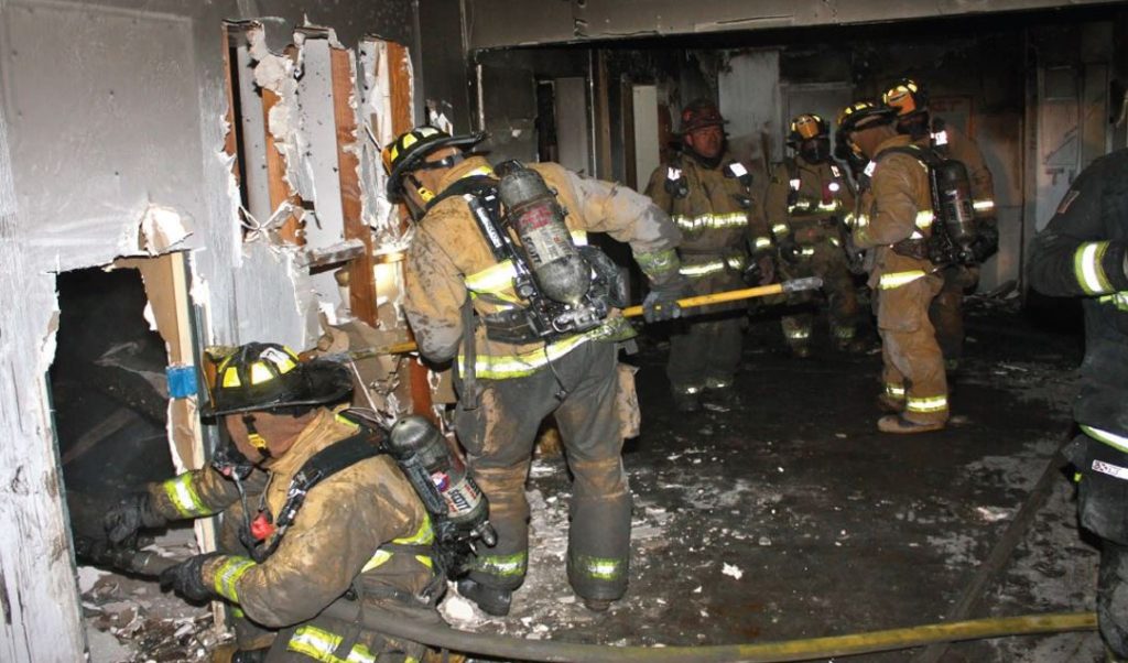 Photo showing firefighter wearing no breathing apparatus during post fire inspection